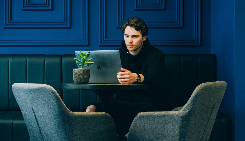 young man working on laptop in coworking workspace